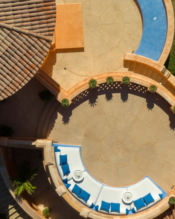 Aerial view of a patio area with blue cushions and a pool.