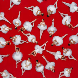 Repetition of ballerinas in white tutus on a red background